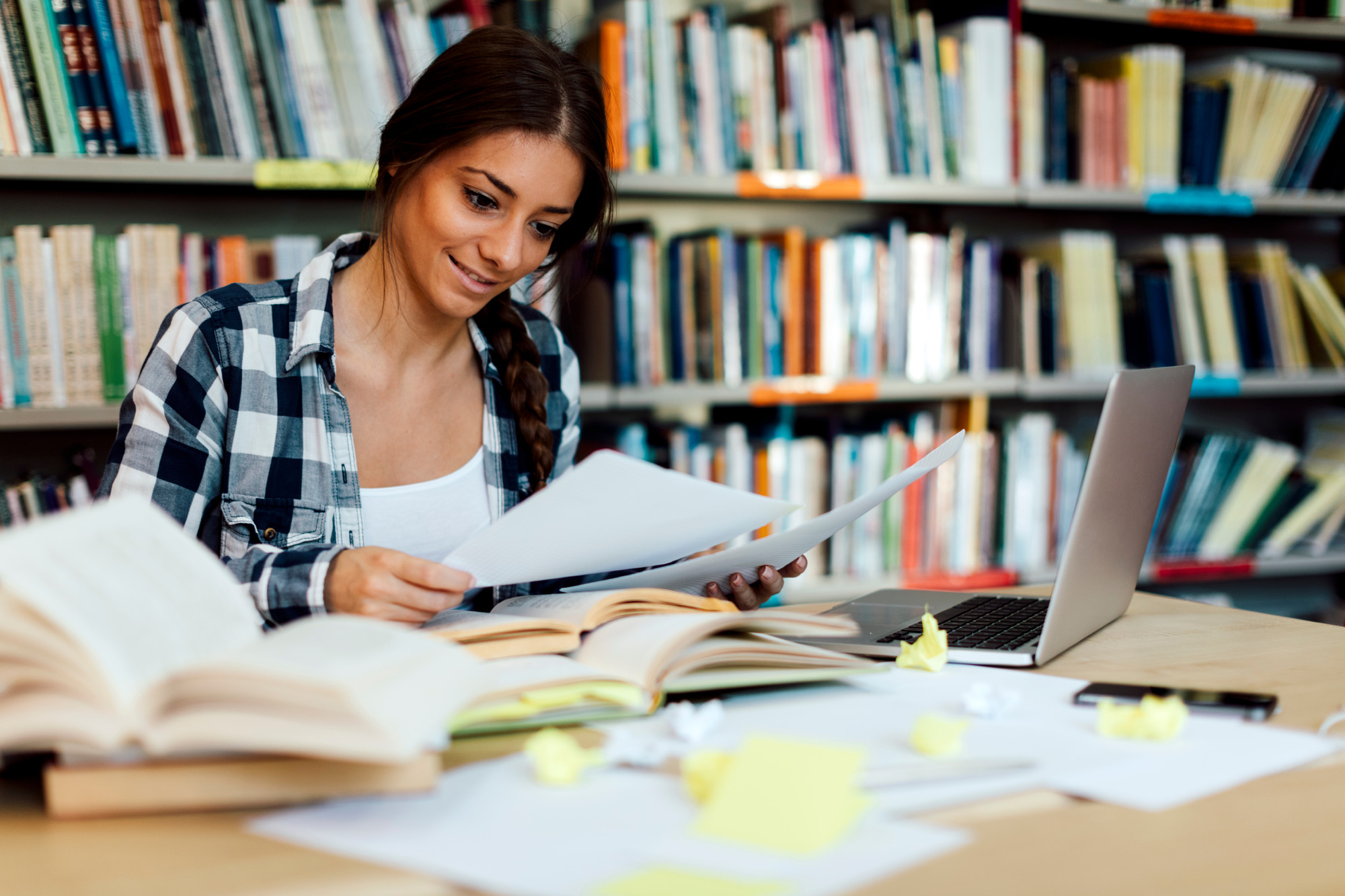 Female student using laptop for taking notes to study